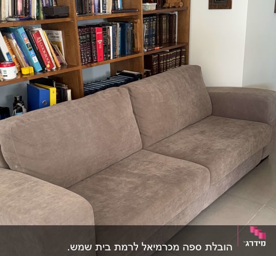 ספה חומה על רצפת אריחים ליד מדף ספרים